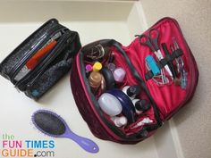 an open suitcase sitting on top of a counter next to a hair brush