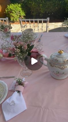 the table is set with pink flowers and teapots for an afternoon tea party