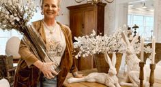 a woman standing in front of some fake flowers