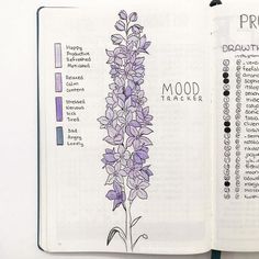 an open notebook with purple flowers on it and the words mood tracker written in black ink