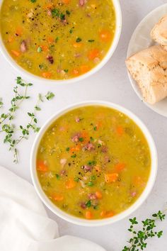 two white bowls filled with soup next to bread