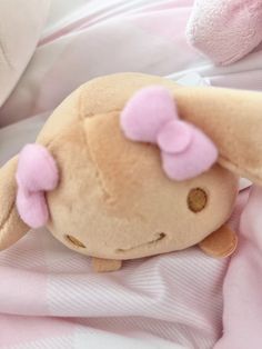 a stuffed animal laying on top of a pink blanket