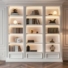 a white bookcase with many books on top of it and some lights in the middle