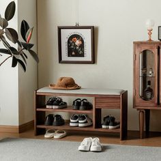 there is a shoe rack with shoes on it in the corner next to a cabinet