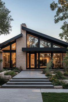 a modern house with large windows and steps leading up to the front door is shown