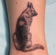 a tattoo on the leg of a person with a dog's head and tail