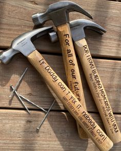 two hammers and some nails on top of a wooden table with words written on them