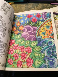 an open coloring book with colorful designs on it