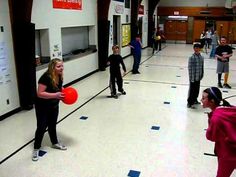 a group of people playing with frisbees in a gym