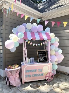 an ice cream stand with balloons and streamers