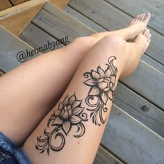 a woman's legs with tattoos on them and her leg showing the flower design