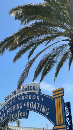 a blue and yellow sign that reads south florida yacht harbor fishing boating cafes under a palm tree