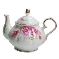 a white tea pot with pink roses painted on the side and gold trimmings