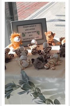 stuffed animals are sitting on a table with a sign in front of them that says there is no animal