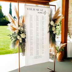 a wedding seating chart with flowers and feathers