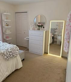 a bedroom with a bed, dresser and mirror