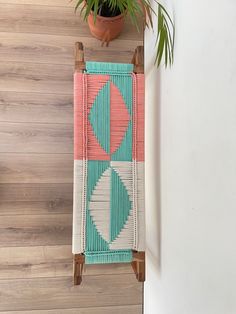 an overhead view of a potted plant next to a rug on a wooden floor