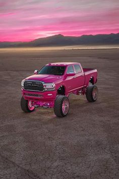 a pink truck is parked in the desert