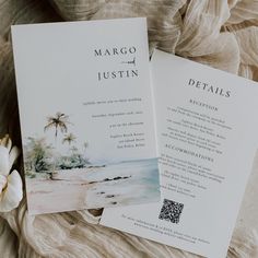 two wedding programs are laying on a bed next to a white flower and some fabric