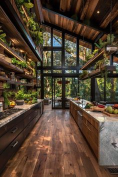 an open kitchen with wooden floors and lots of plants growing on the wall above it