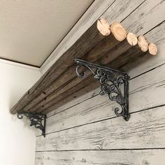 an old fashioned shelf is hanging on the wall next to a light fixture and wood planks