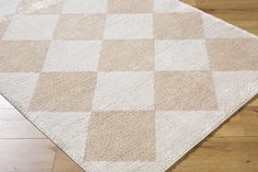 a beige and white checkered rug on the floor