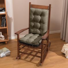 a rocking chair with a cushion on it in front of a book shelf and bookshelf