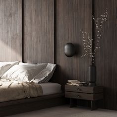 a bed sitting next to a wooden wall