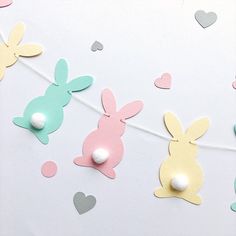 paper bunnies are hanging on a string with hearts and confetti in the shape of rabbits