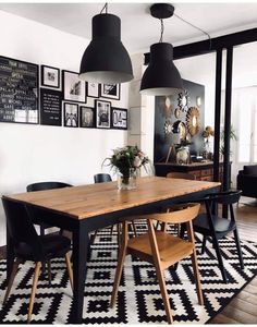 a dining room table with chairs and pictures on the wall in front of it,