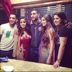 a group of people standing next to each other in front of a wooden counter top