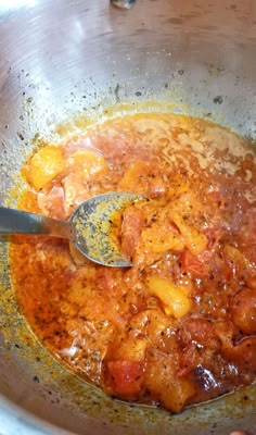 the food is being cooked in the pot with a ladle on top of it