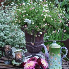 a table with flowers and tea cups on it