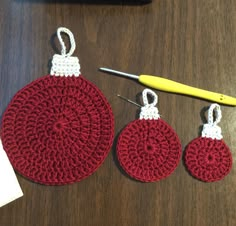 three crocheted ornaments are sitting on a table next to a pair of scissors