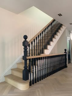 a staircase with black railing and wooden handrails