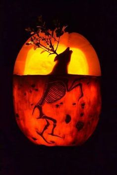 a carved pumpkin with a wolf on it's face and moon in the background