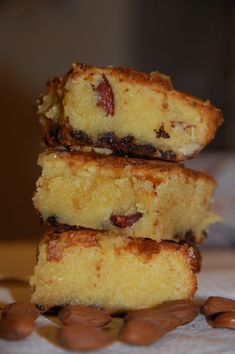 three pieces of cake stacked on top of each other with almonds around the edges