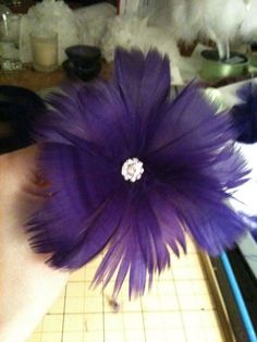 a purple flower with a diamond in the center sitting on a cutting board next to scissors