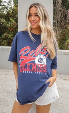 For those Ole Miss Rebels! This navy blue tee features a red "REBS" with the iconic Ole Miss football helmet. Elle is 5'10" and is wearing size medium tucked Mary Claire is 5'9" and is wearing size XL for an oversized look sizing guide: fits true to size - size up for an oversized fit medium measurements: 41" bust and 28.5" length 100% cotton WE ONLY OFFER STORE CREDIT FOR RETURNS! Feel free to email us at orders@shopriffraff.com or DM us with any questions regarding fit, styling, or our return Ole Miss Game Day Outfit, Powder Blue Dress, Hamptons Summer, Sports Outfits, College Gear, Dream College