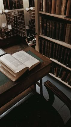 an open book sitting on top of a wooden table in front of a bookshelf