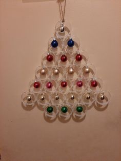 a christmas tree ornament hanging on a wall with baubles in it