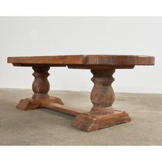 an old wooden table with two turned legs