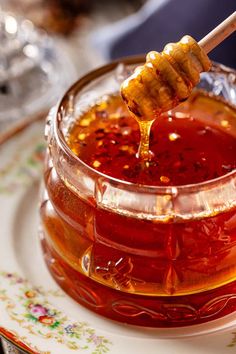 a glass jar filled with honey sitting on top of a plate