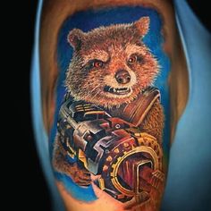 a man's leg with a tattoo on it that has a rocket ship and a raccoon