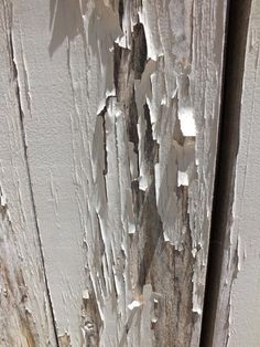 peeling paint on the side of an old wooden door that has been stripped and chipped