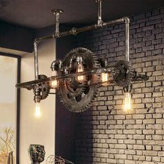 an industrial style chandelier hanging from a brick wall in a living room with exposed lighting