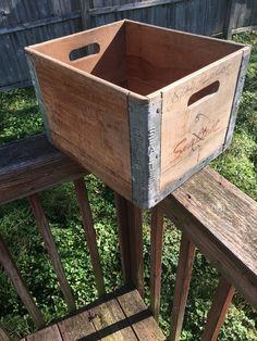 a wooden crate sitting on top of a wooden bench