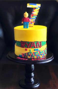 a cake decorated with lego blocks and a man on top