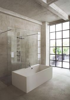 a bathroom with a tub, shower and glass doors on the outside wall is shown