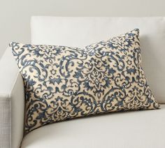 a blue and white pillow sitting on top of a couch